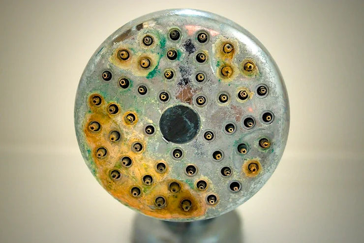 Limescale buildup on shower fixtures from hard water mineral deposits